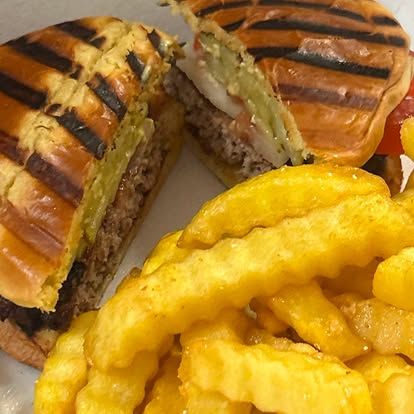 Grilled panini halves with crinkle-cut fries