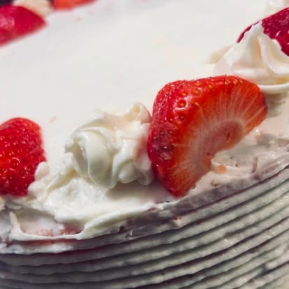 Slice of cake topped with strawberries and cream