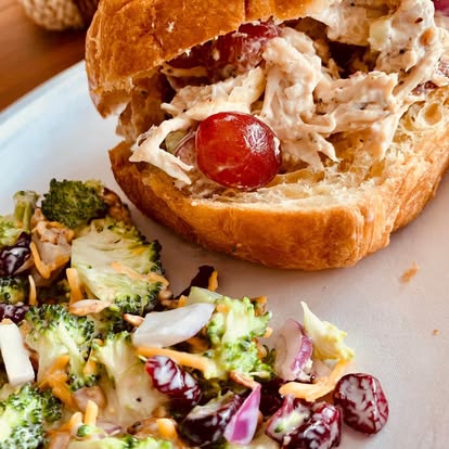 Chicken salad croissant sandwich with a side salad