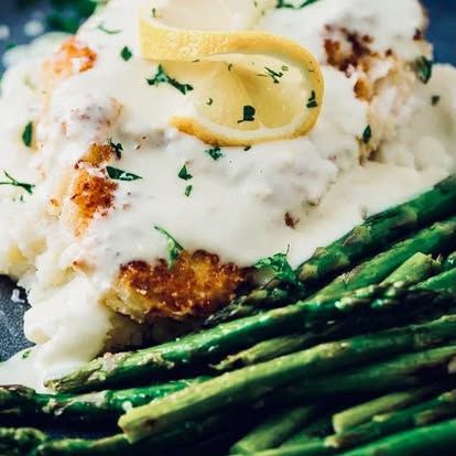 Fish fillet over asparagus and mashed potatoes